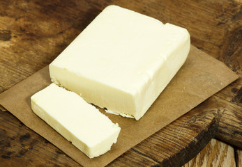 Piece of butter on the wooden cutting board