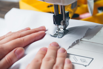 Hands of young girl on sewing machine