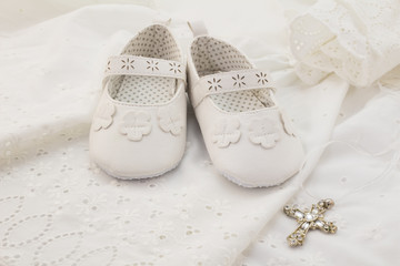 Baby christening white shoes with cross pendant on white