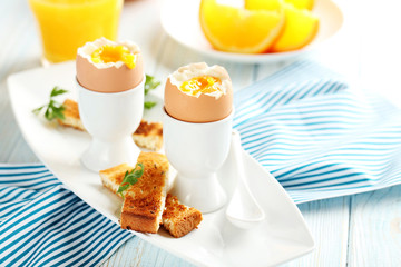 Boiled egg with toasts on a blue wooden table