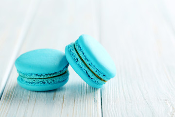 Tasty blue macarons on a blue wooden table