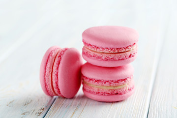 Tasty pink macarons on a blue wooden table