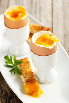 Boiled egg with toasts on a grey wooden table