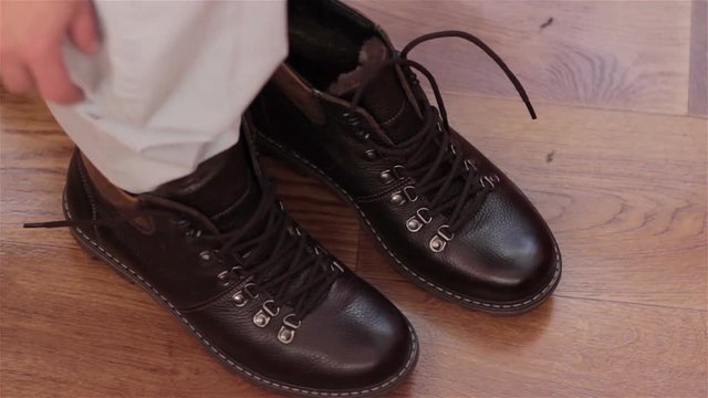 Man Putting On Boots/New classic boots put on the floor