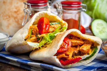 Fried chicken meat with vegetables in pita bread