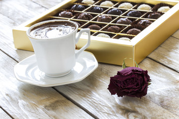 Turkish coffee, truffle chocolate and dried rose on wooden table