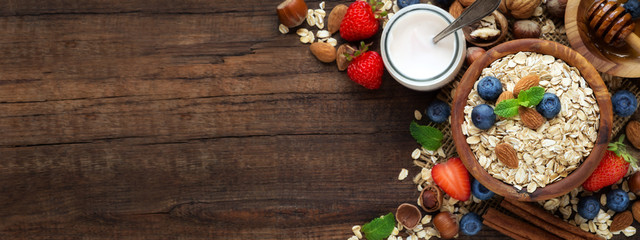 Healthy breakfast with oat flakes, natural yogurt, fresh blueberries, strawberries, almonds and honey. Overhead view with copy space for your text - obrazy, fototapety, plakaty