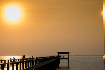 Fototapeta premium Beautiful sunset on beach and bridge in silhouette twilight golden hour/Sunset on beach and bridge silhouette