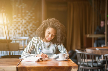 Pretty african woman is learning subject in cafeteria