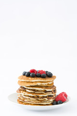 Pancakes with blueberries and raspberries isolated on white background
