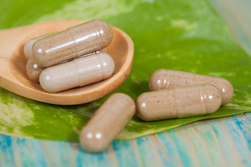 Capsules of herbs on spoon. healthy eating for healthy living.