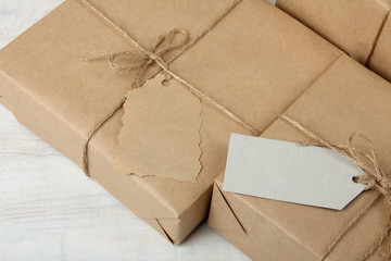 two parcels with  tag on white wooden background