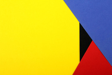 Color papers geometry flat composition background with yellow red blue and black tones