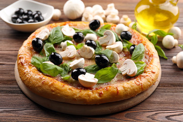 Delicious tasty pizza with ingredients on wooden table