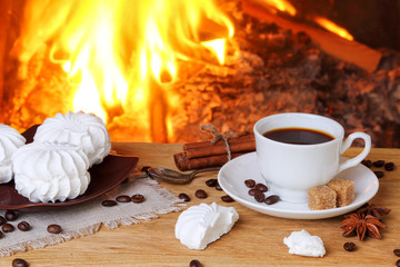 Coffee with spices and marshmallows on a background of a burning