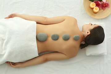 Spa concept. Woman relaxing with pebbles on her back