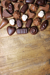 Delicious chocolate candies on wooden background
