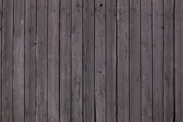 fence of vertical old brown purple planks or side of shed