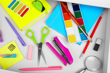Stationery in open desk drawer, top view