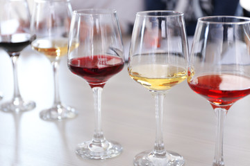 Many glasses of different wine in a row on a table. Tasting wine concept