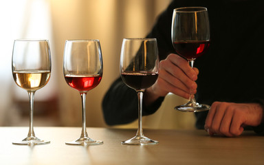 Man holding a glass of red wine at the table