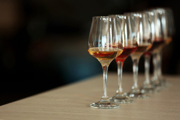 Many glasses of different wine in a row on a table