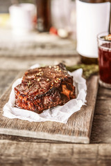 Roasted pork steak with wineglass  and spices on wooden background