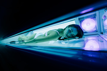 Beautiful woman tanning in solarium