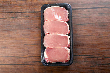 Packed pieces of pork meat on wooden background