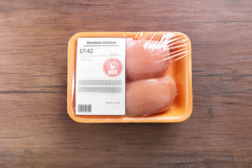 Packed pieces of chicken meat on wooden background