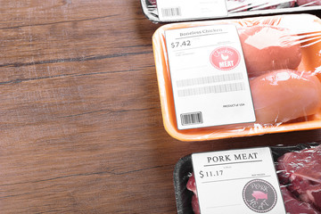 Packed pieces of chicken and pork meat on wooden background