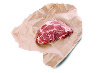 Row pork steak with paper, isolated on white