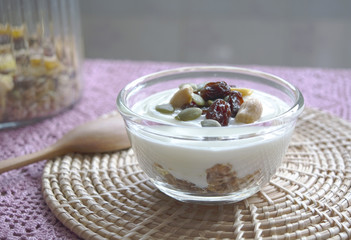 Yogurt with granola and pumpkin seeds, nuts and raisin on top
