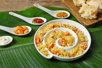 Fried rice with flat bread and spices on banana leaf background
