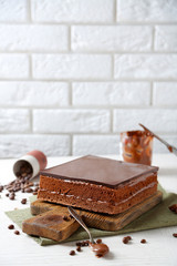 Delicious chocolate cake on wooden cutting board closeup