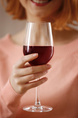 Young woman with glass of red wine closeup