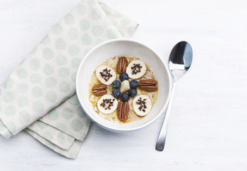 Porridge with banana, nuts, topping and chocolate crumbs