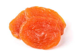 three dried apricots on a white background closeup