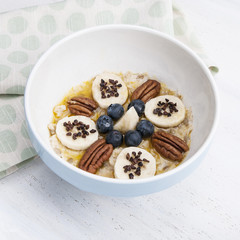 Porridge with banana, nuts, topping and chocolate crumbs