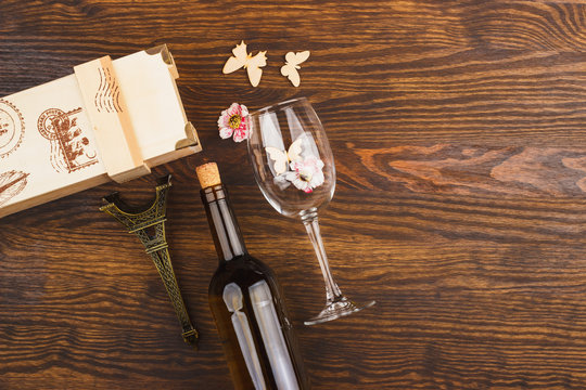 Wineglass and bottle with decorative flowers and butterflies
