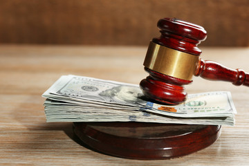 Obraz na płótnie Canvas Law gavel with dollars on wooden table background, closeup