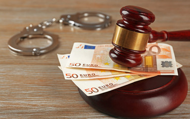 Law gavel with euro and handcuffs on wooden table background, closeup