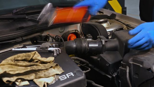 Mechanic gets angry while repairing gasoline car engine
