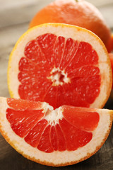 Sliced grapefruits on wooden background, close up