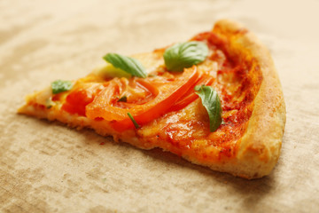 Margherita pizza slice on cardboard background