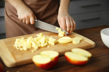 Obraz na płótnie Canvas Woman chopping ripe apple on a cutting board
