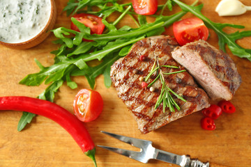 Delicious grilled steak on cutting board, closeup
