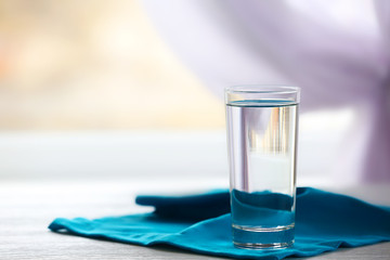 Glass of water on a blue napkin, close up