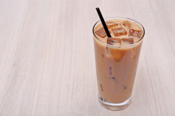 Coffee with ice on light wooden background