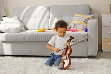 Little boy learning to play violin. © Africa Studio